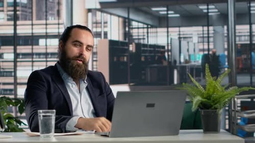 Bearded Man Attends Virtual Meeting in Office