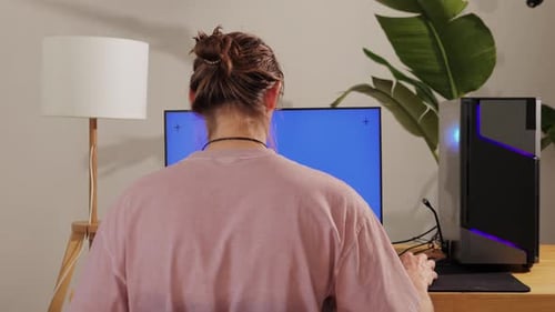 Ordinateur avec Chroma Key, écran vert sur le moniteur, joueur, joueur, jouant dans un programmeur de jeux vidéo populaire