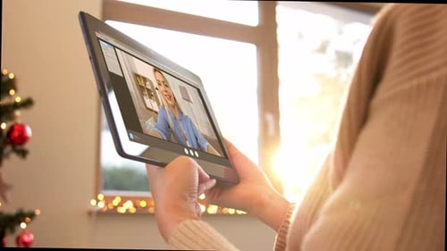 Woman video calling on a tablet at Christmas