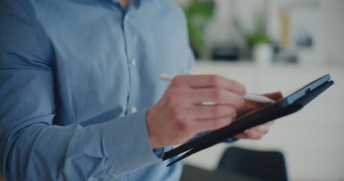Man Using Tablet and Stylus Indoors Daytime