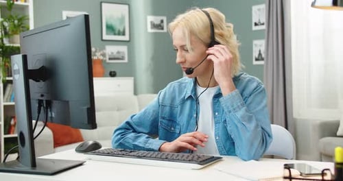 Woman Talks on Headset at Computer Desk