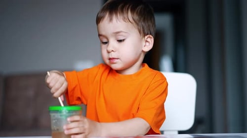 Boy Diligently Painting Indoors at Home
