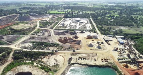 Aerial hyperlapse of heavy machinery moving soil and minerals from one location to another.