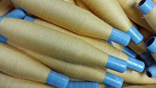 Close Up Textile Yarn Spools on Blue Bobbins