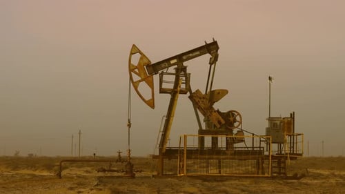 Pumping Petroleum Rig in Desert at Sunset Oil Industry Pump Jack Extracting Crude Oil From a Oil