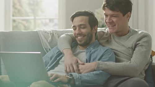 Affectionate Young Men Watching Laptop Together on Couch
