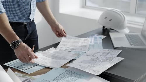 Architect Reviews Blueprints in Office Environment