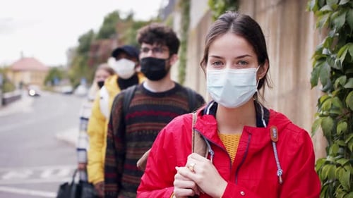Young People Standing Outdoors in Town, Looking at Camera. Coronavirus and Safe