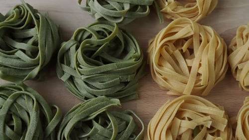 Uncooked Ribbon Pasta Nests on Wooden Surface