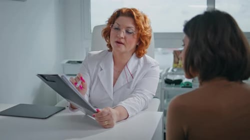 Healthcare Practitioner Showing Papers to Patient at Clinic Examination Closeup