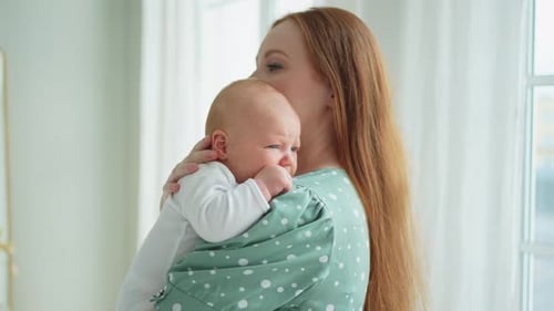 Mother Holding Her Baby in a Bright Room