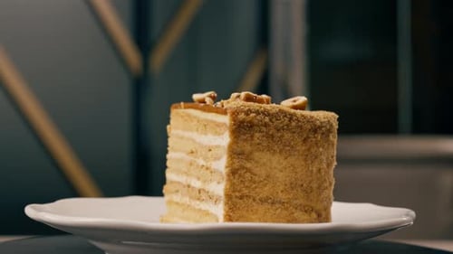 A dessert close-up of a piece of delicious honey cake lying on a white plate in Italian restaurant