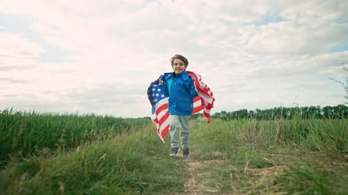 Boy Runs with American Flag in Grassy Field