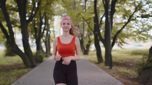 Athletic Woman Jogging Checks Smartwatch in Green Park