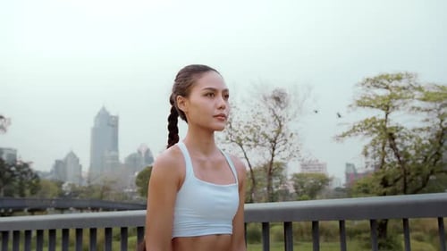 Young fitness woman in sportswear jogging in city park