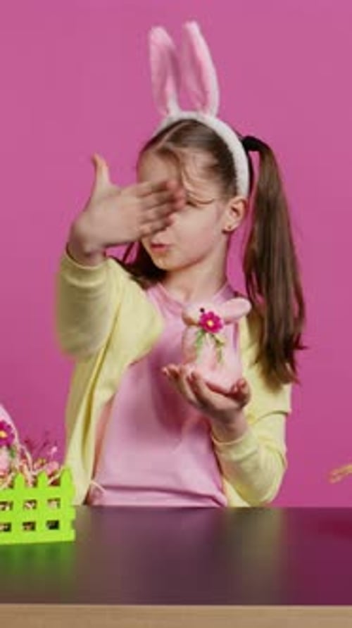 Cheerful Girl with Bunny Ears Holds Easter Decoration