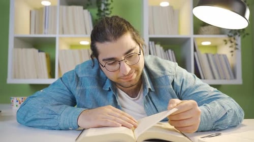 Close-up shot of young man reading a book.