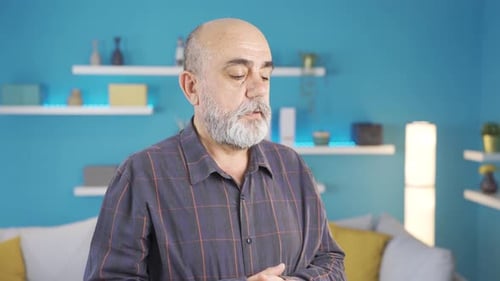 Sad and grieving old man thoughtful at home.