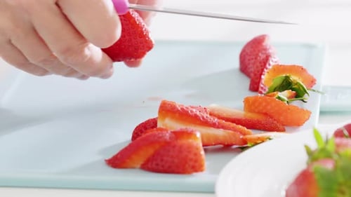Cutting Fresh Strawberries on Light Blue Cutting Board