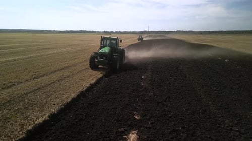 Green Tractor Plowing the Fields with Plow