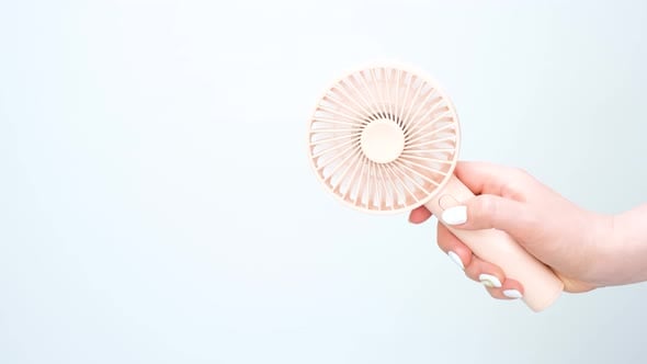 Female hand holding a small fan on white background close-up., Stock ...