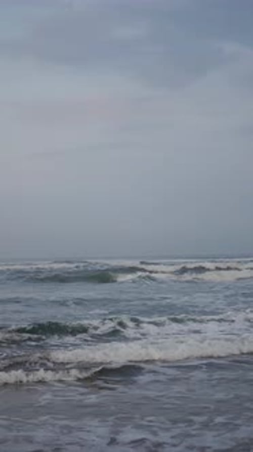 Beautiful vertical beach portrait video in the morning, beautiful view of small waves and beach