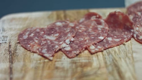 Smoke Transformation Effect of Heart Shapes of Fresh Italian Sliced Salami Sausage on a Wooden Tray