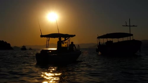 Fisherman on Boat Against Dusk Horizon
