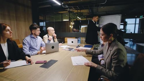 A Team Meeting is Taking Place in a Contemporary Modern Office Environment Featuring a Presentation