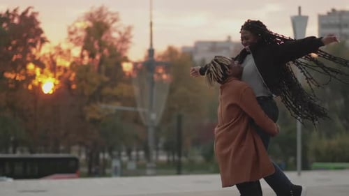 Loving Couple Embracing During Vibrant Sunset in City