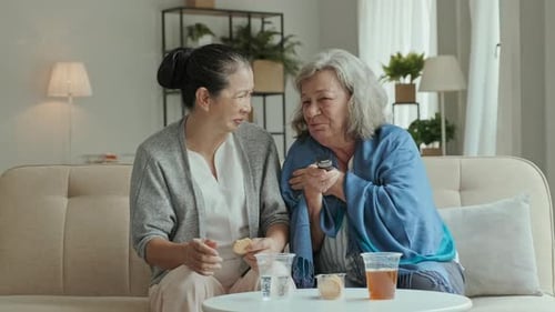 Senior Women Chatting on Couch with Drinks