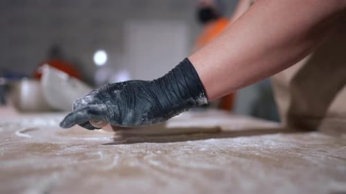 Side View Woman Rolling Out Dough Sheet with Rolling Pin in Kitchen Closeup Unrecognizable Caucasian