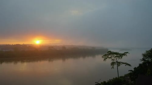 Zeitraffer von Sonnenaufgang bis Sonnenaufgang an einem Fluss an einem bewölkten Tag.