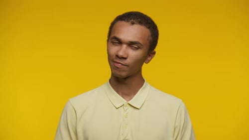 Thoughtful Young Man Contemplates on Yellow Background