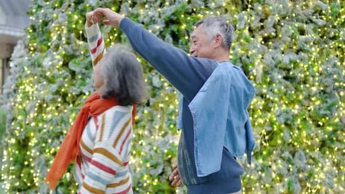 Happy Senior Couple Dancing Near Christmas Tree