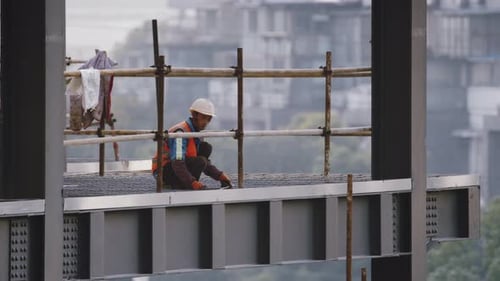 Construction Worker Squatting on Steel Floor