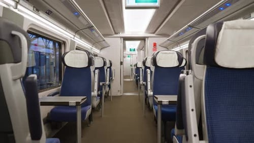 Intérieur vide du train de première classe avec des sièges et des tables bleus confortables