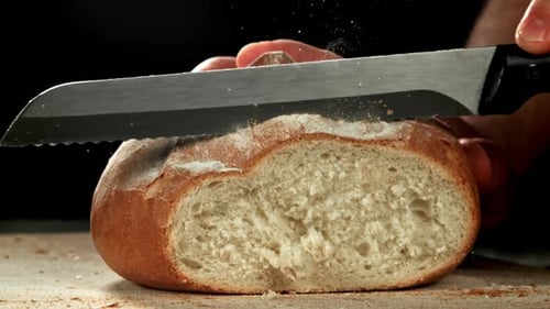 Close Up Slicing Rustic Loaf of Bread