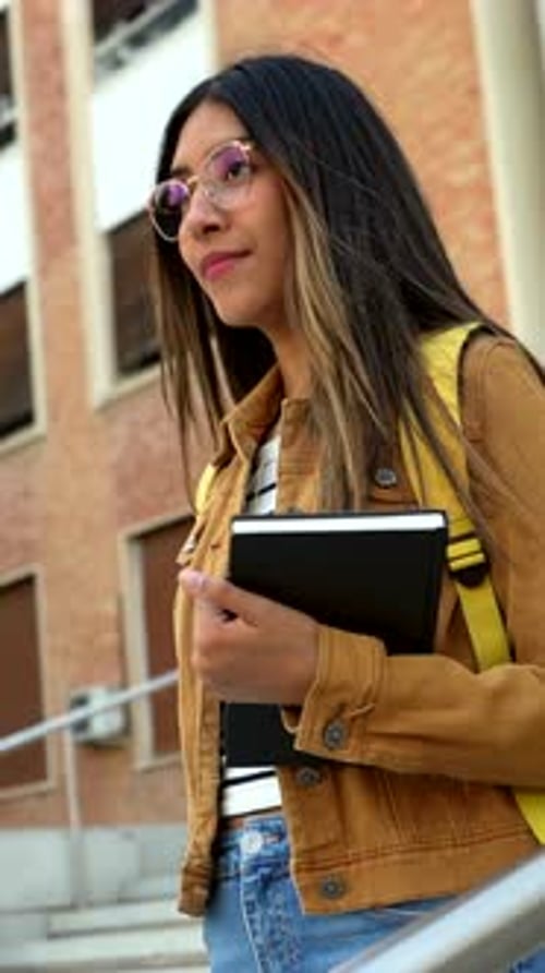 Young Latina University Student Walking on Campus with Books