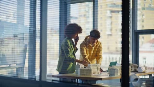 Gebäudedesigner rufen am Telefon an und arbeiten im Büro der Baufirma zusammen