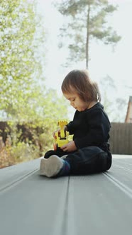 Child Playing with Toy Truck on Deck