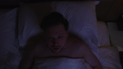 Man Wakes Up in Bed and Seems Anxious