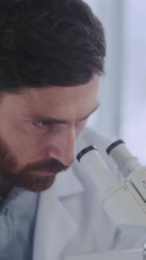 Scientist Uses Microscope in Lab for Research