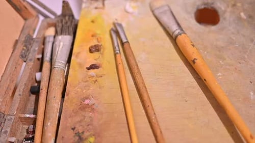 Brushes for paintings lying on a wooden underlay