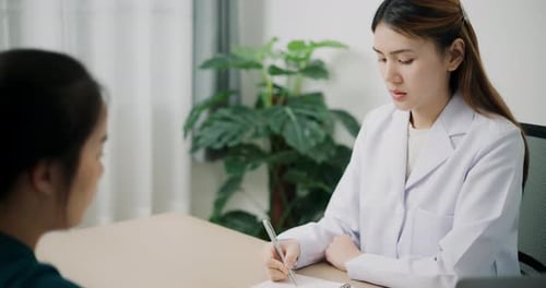 Female Doctor Consults with Patient in Clinic