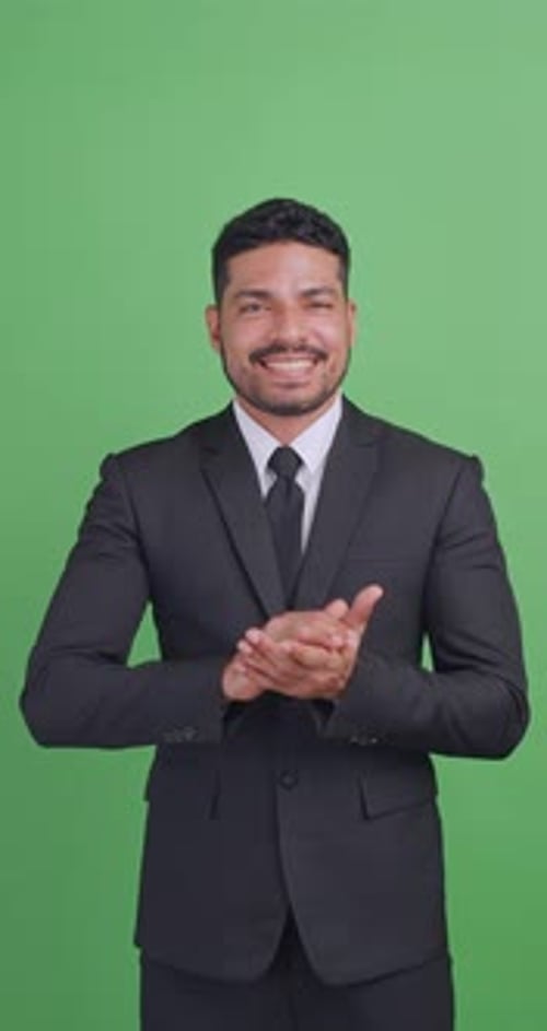 Vertical clip. Asian businessman in a black suit is clapping his hands to congratulate on something.
