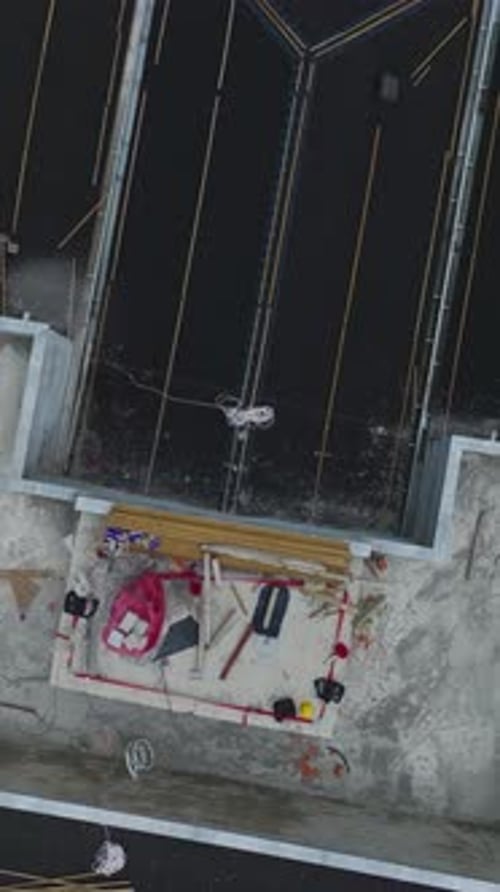 Vertical Video Aerial Shot of a Large Construction Project With Cranes and Active Workers on the