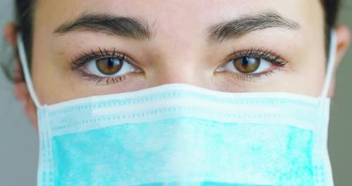 close up portrait of a woman surgeon or doctor with mask ready for operation in hospital or clinic