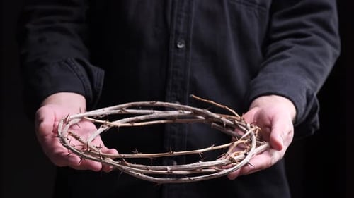 Priest Showing Crown of Thorns on Dark Background for Good Friday or Easter