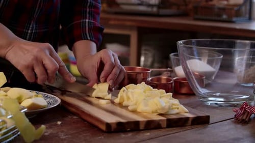 Woman Slicing Fresh Apples on a Wooden Cutting Board in a Rustic Kitchen